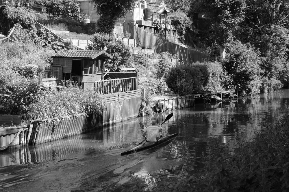 A kayaker powers along the canal