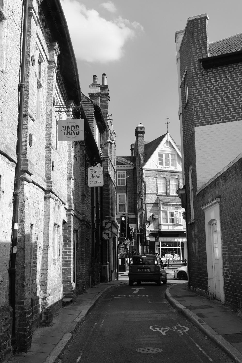A car turns from a sidestreet onto the highstreet