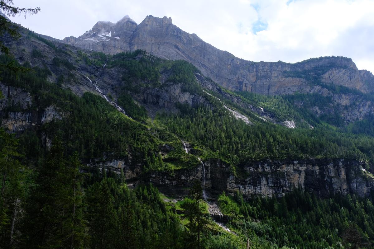 Small waterfalls over a tree covered mountain near Lake Öschinensee, Switzerland