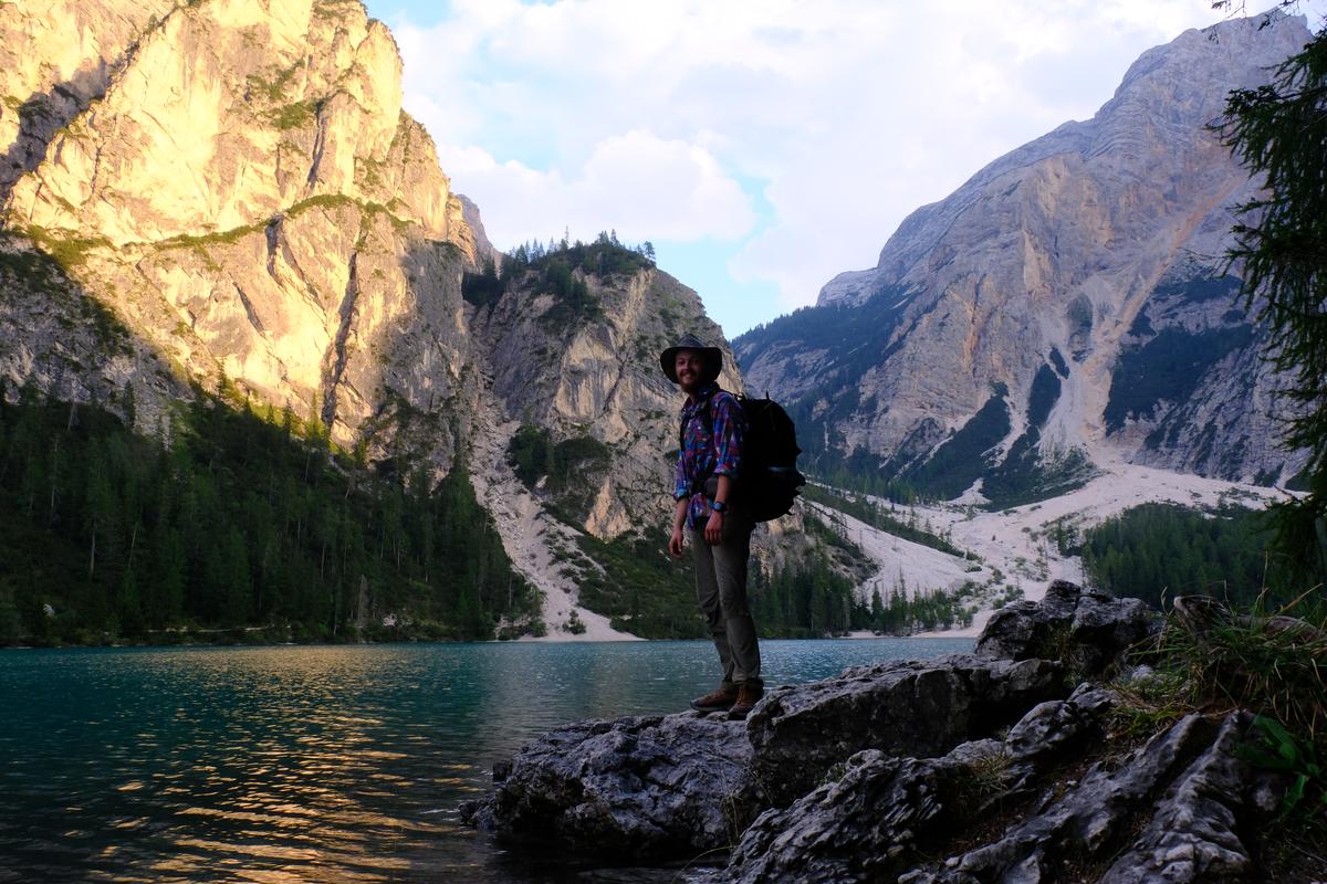 Standing on the shore of Lago di Braies, Italy, the first mountains of the Dolomites behind. 